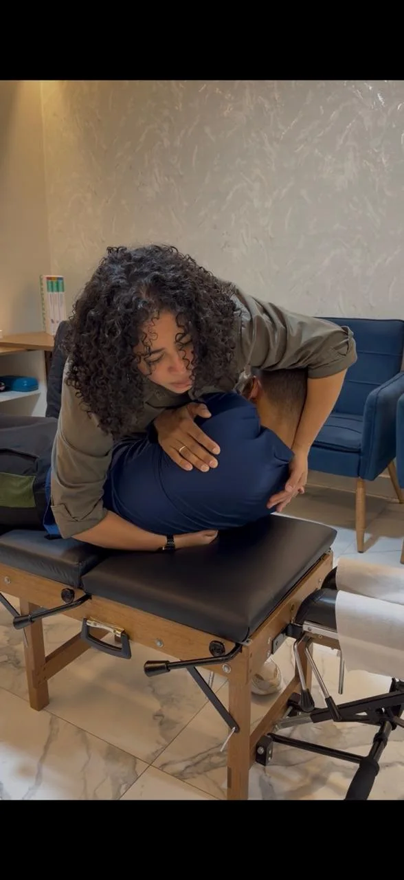 Luciana Lima realizando ajuste com paciente na maca
